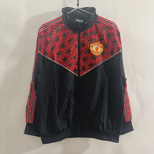 VESTE MANCHESTER UNITED COUPE-VENT 25/26 NOIR ZIGZAG ROUGE