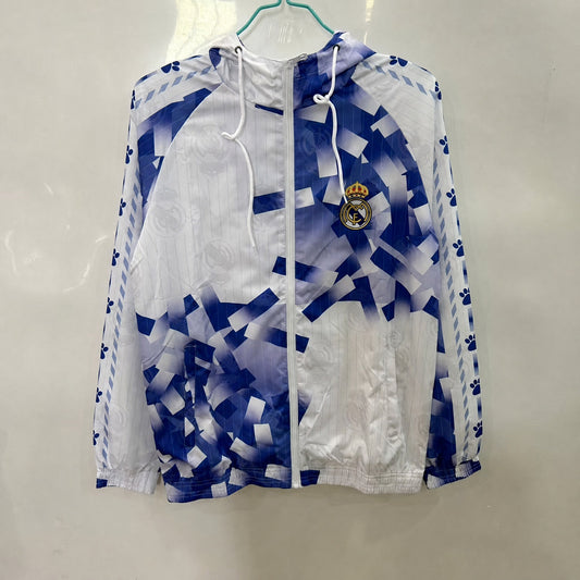 VESTE REAL MADRID COUPE-VENT 25/26 BLANC GÉOMÉTRIQUE BLEU